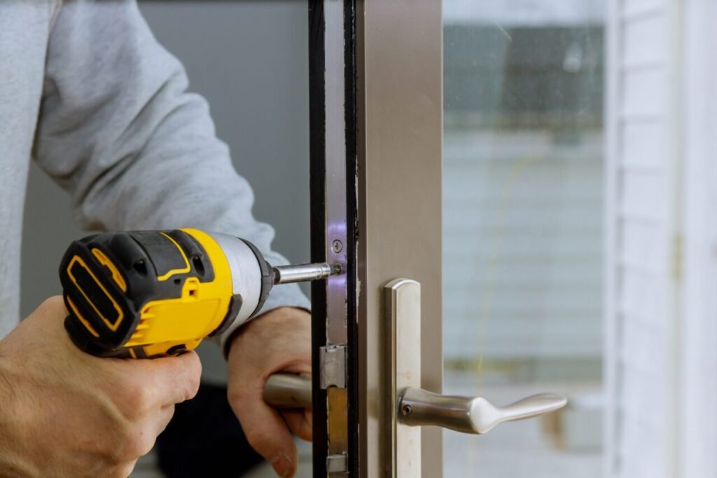 locksmith in installing new house door lock hand holds the screwdriver 1 e1696321492527